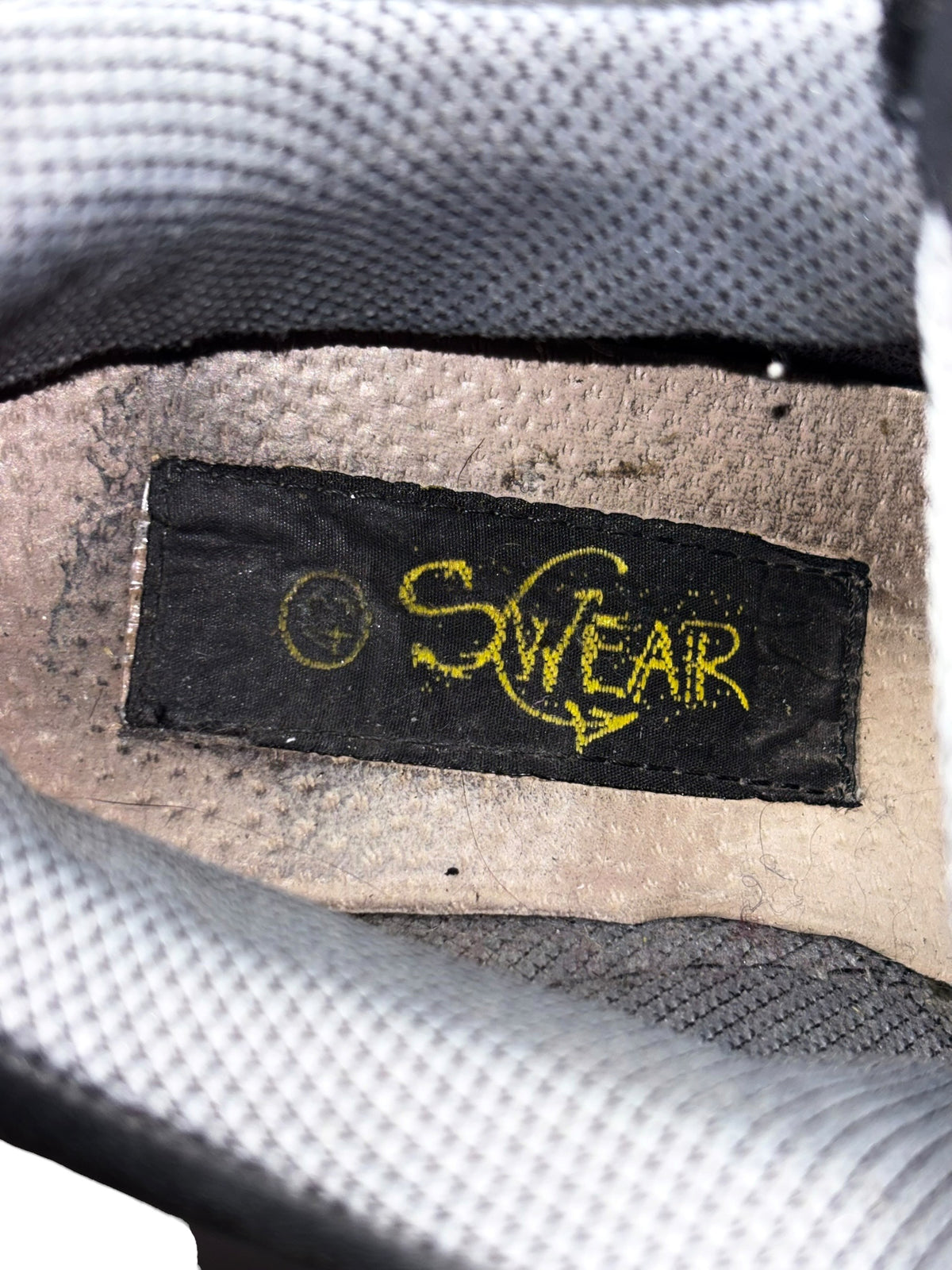 Platform boot insole label with “Swear” logo, shown in close-up.