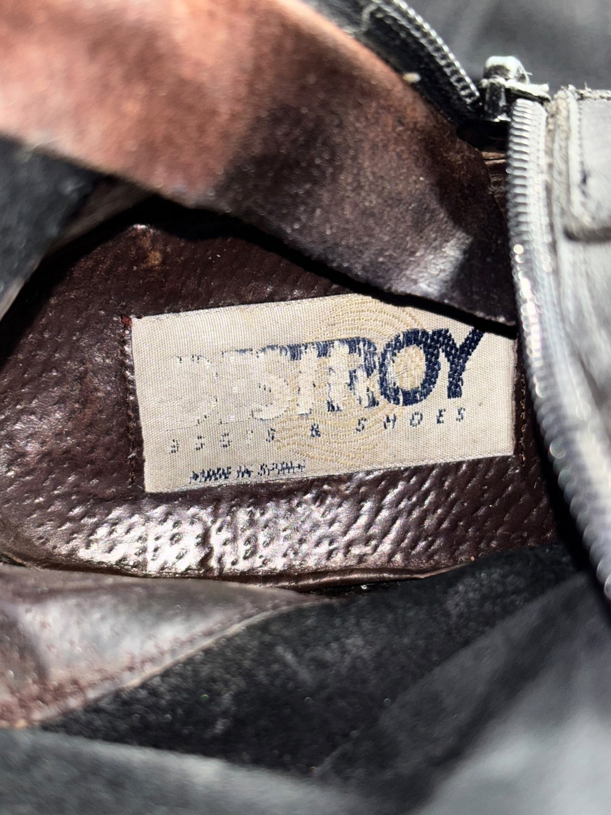 Knee-high leather boots, dark interior with 'DESTROY' label and zipper pull detail