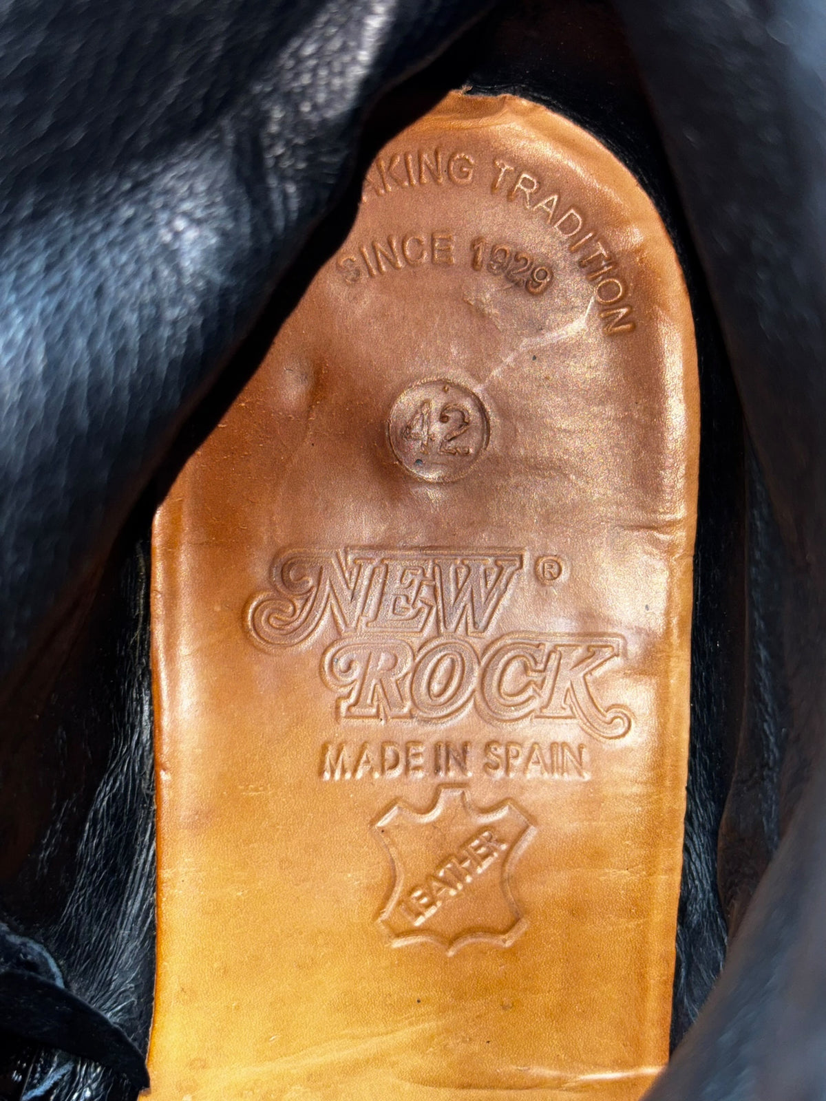 Vintage cowboy boots with studded details; tan leather interior with branding stamp.