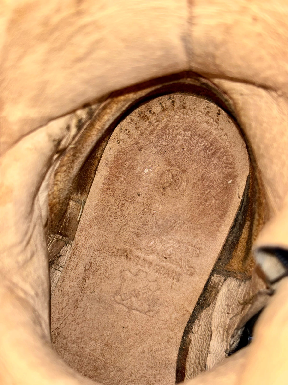 Biker boot interior view with light tan suede insole and stitching