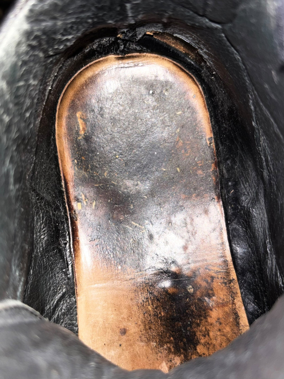 Worn leather sneaker insole detail with stitched edge and dark exterior strap