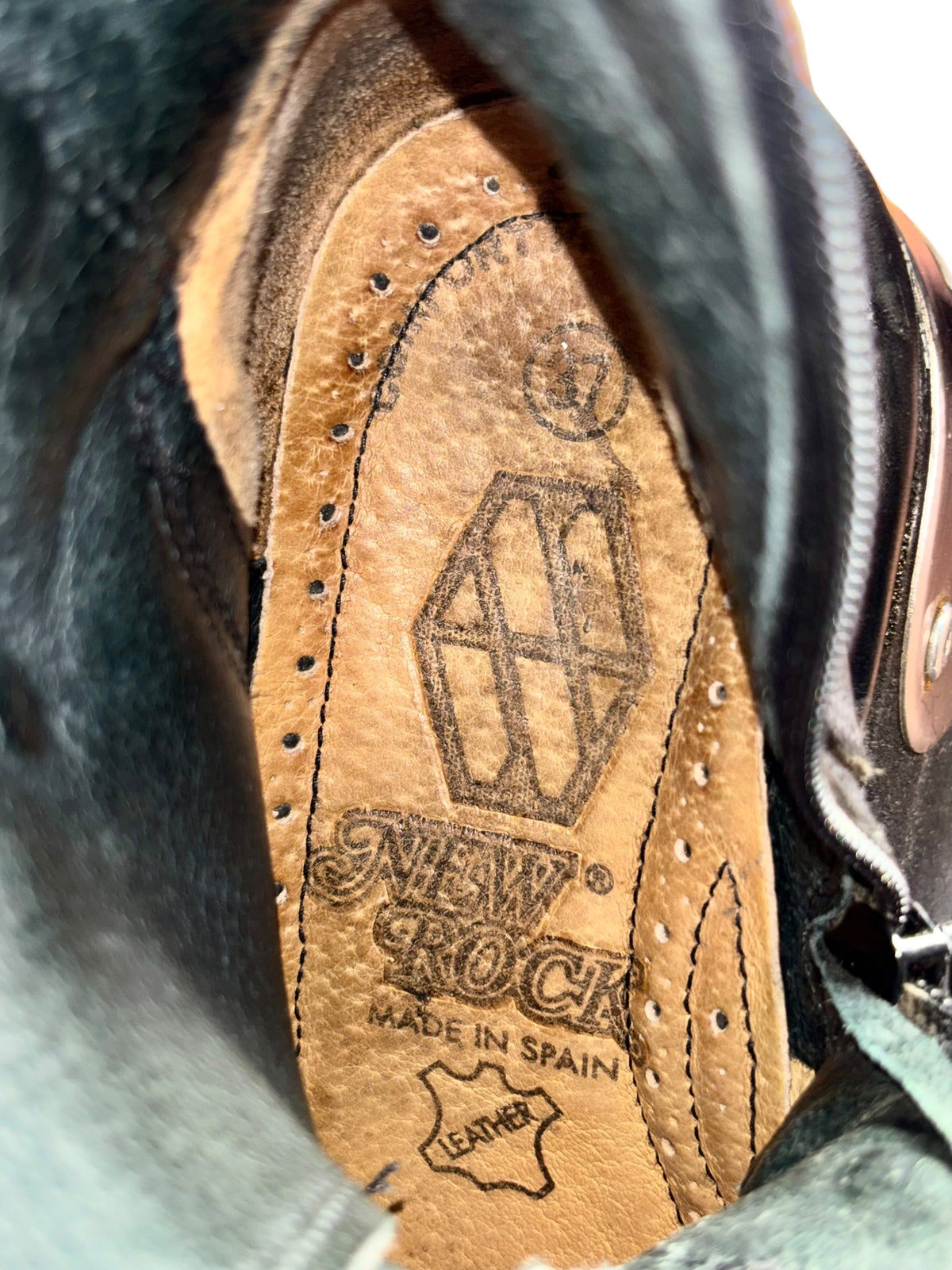 Black and tan boot insole with printed brand graphic and “Made in Spain” text