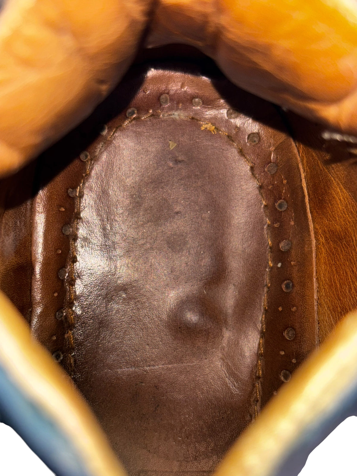 Platform boot interior lining with stitched leather and eyelets near the heel.
