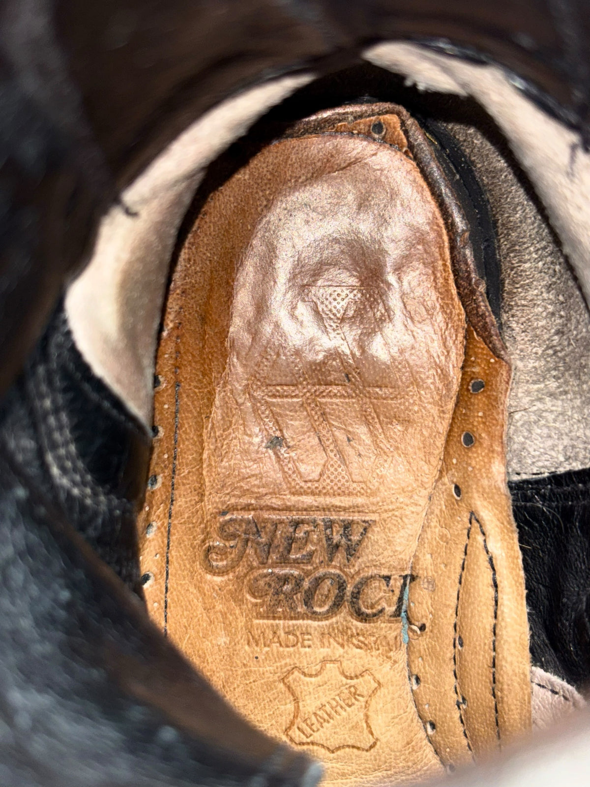 Tan leather boot insole with embossed New Rock logo and stitched edges