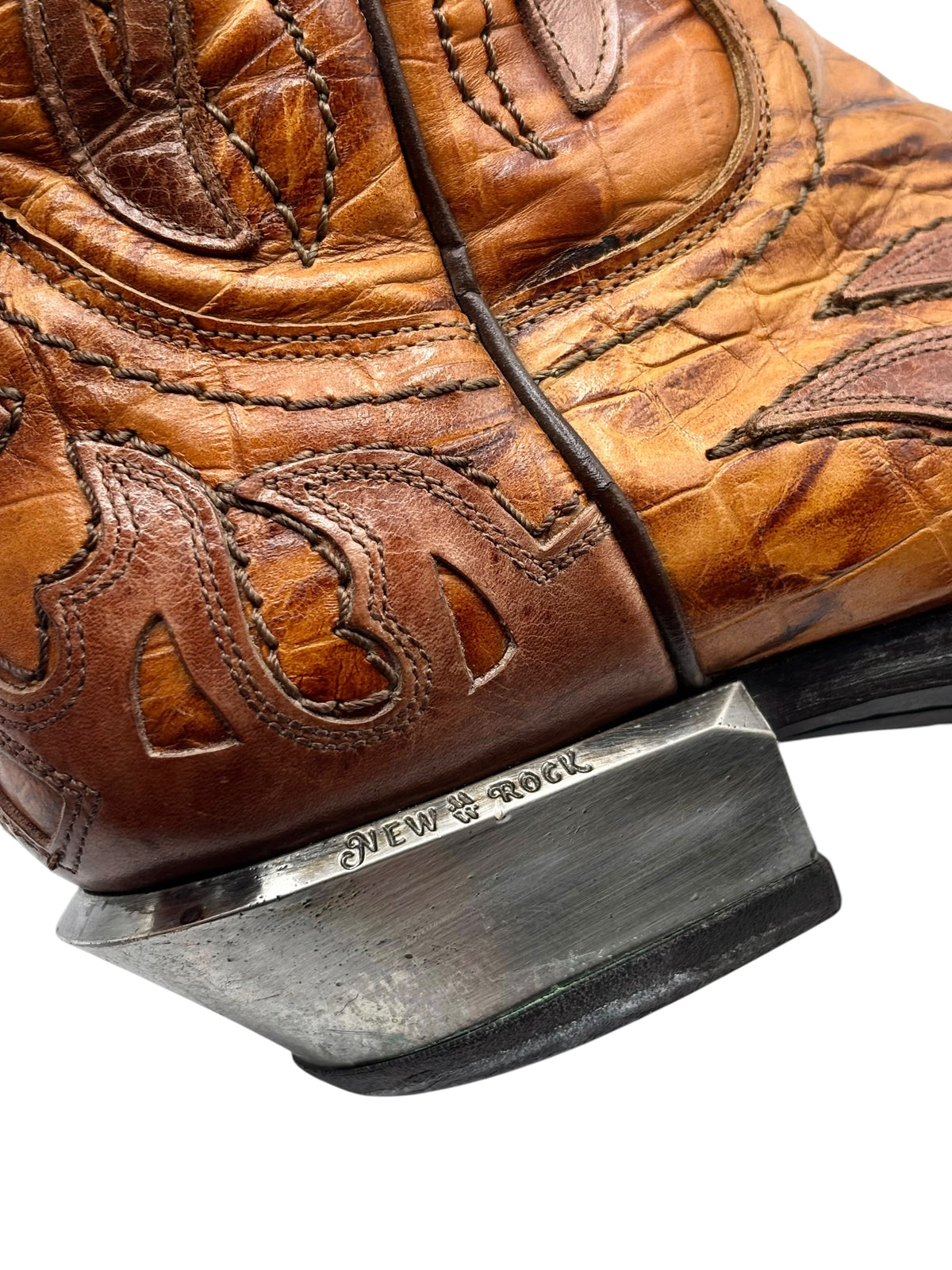 Brown boot toe and side close-up with metal heel plate and stitched pattern