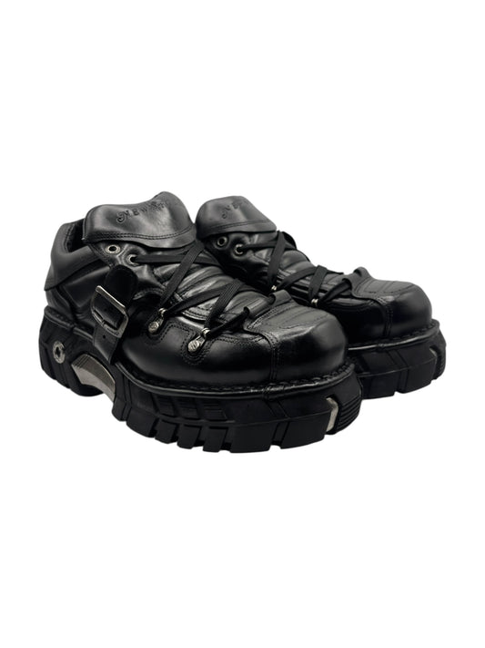 Black platform lace-up boots with buckled strap and rugged tread sole