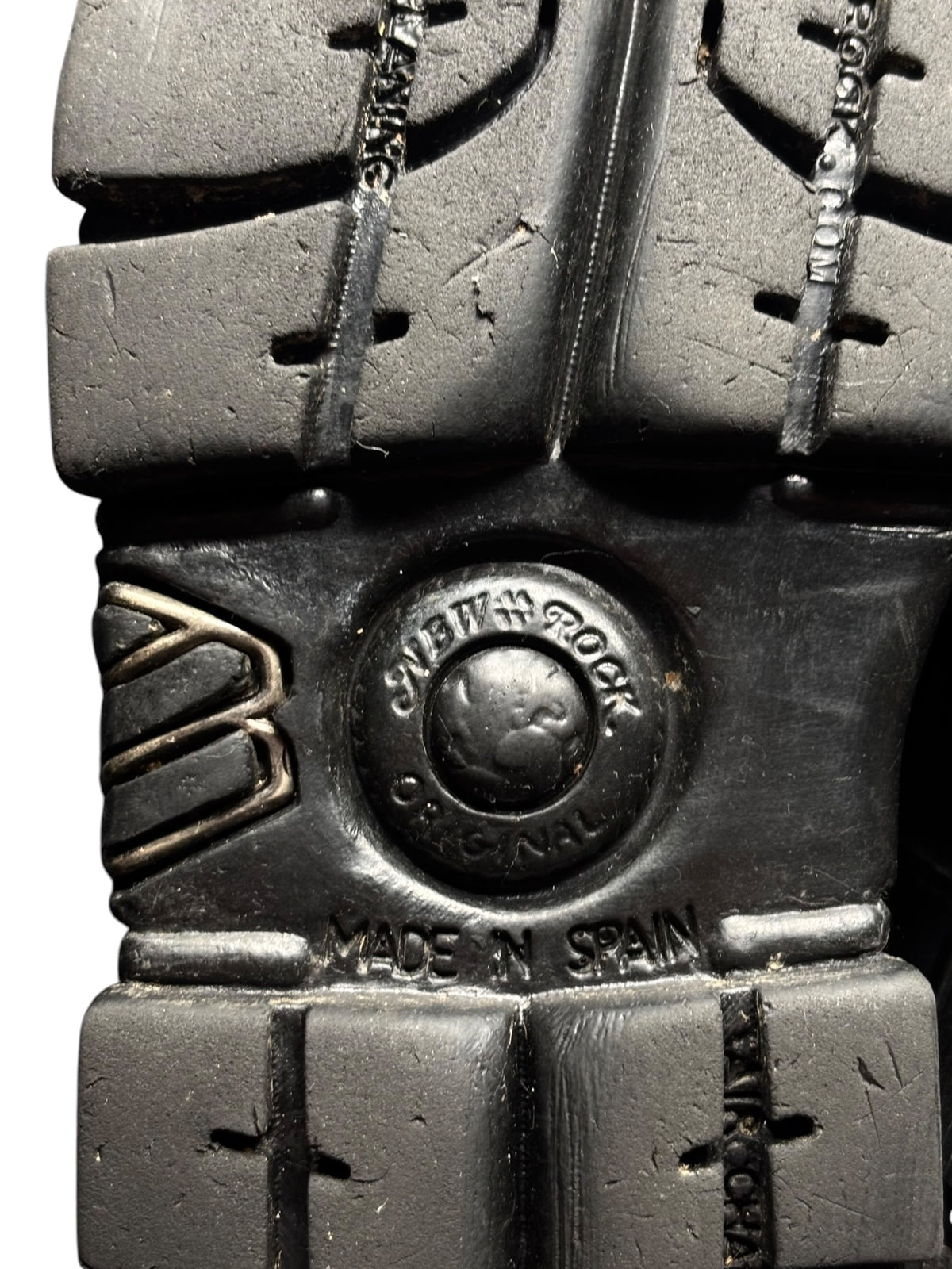 Vintage platform boots, black outsole close-up with round brand medallion and text.