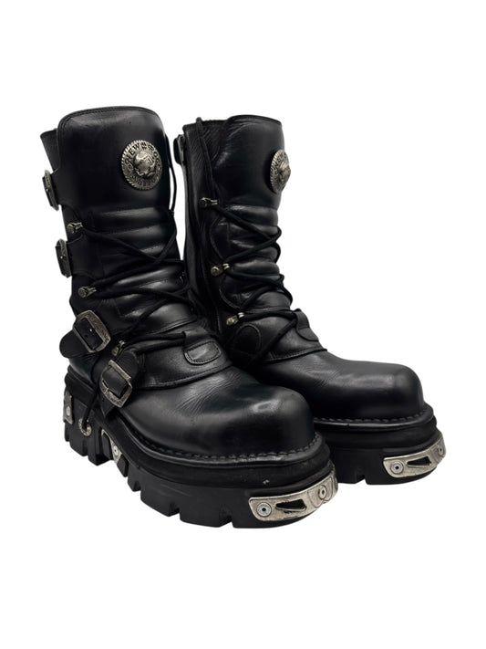 Mid-calf black lace-up leather boots with side buckles and chunky tread sole