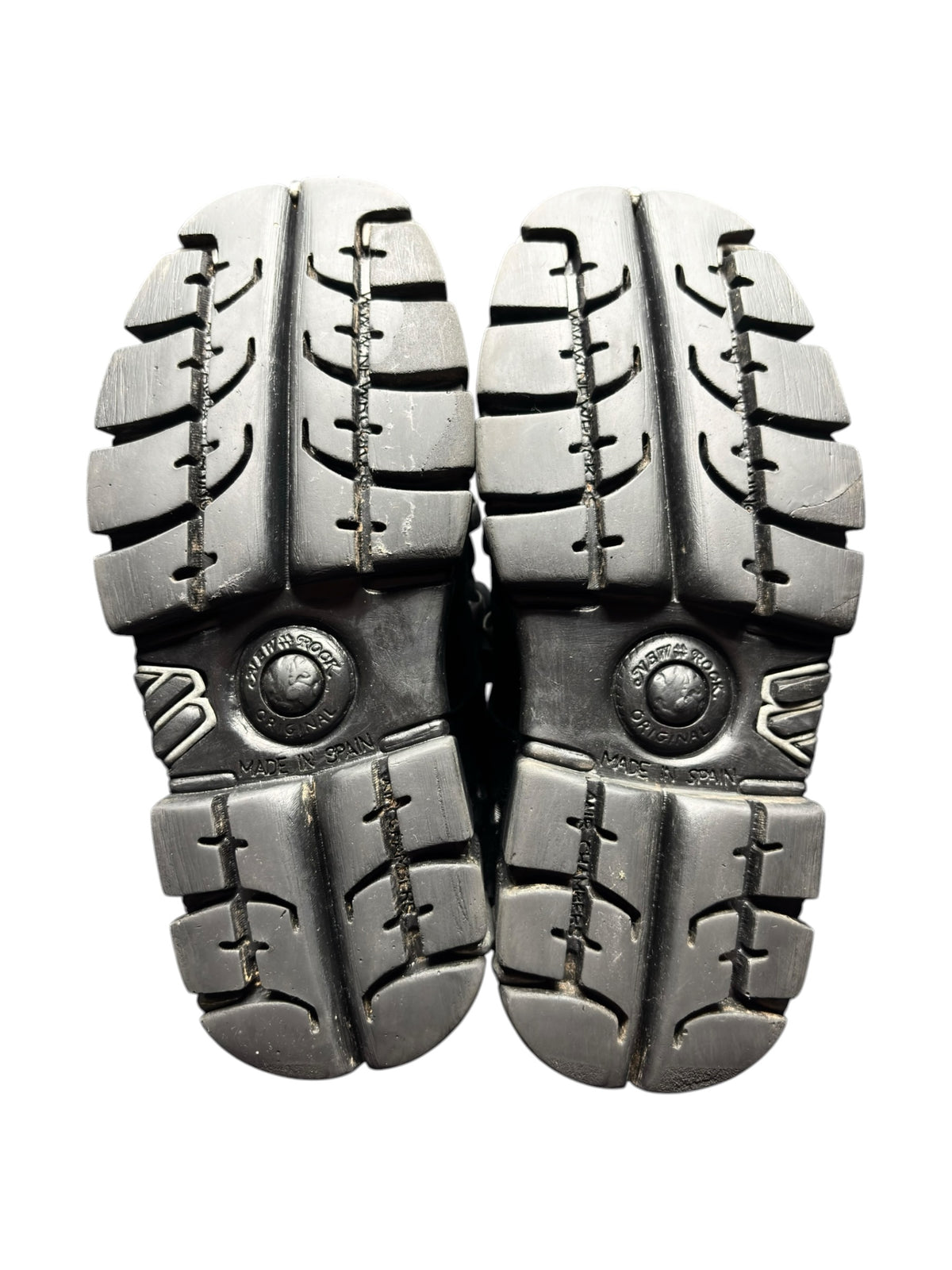 Black platform boots outsole view with chunky tread and circular logo rivets