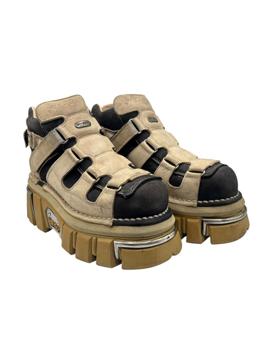 Pair of beige platform ankle boots with black toe caps and ribbed tread soles