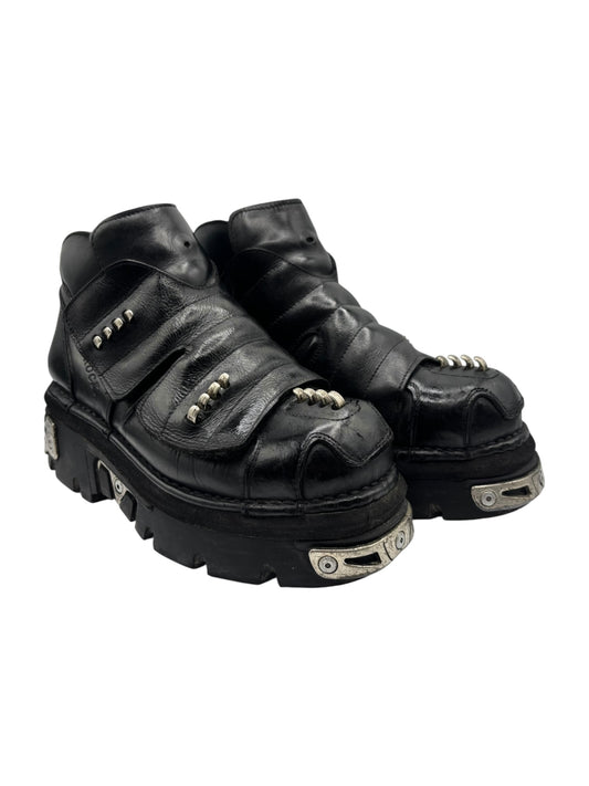 Black leather chunky platform boots angled view with side straps and thick outsole