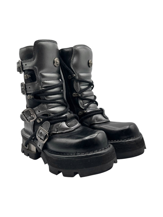 Mid-calf leather lace-up boots with buckles and chunky black sole.