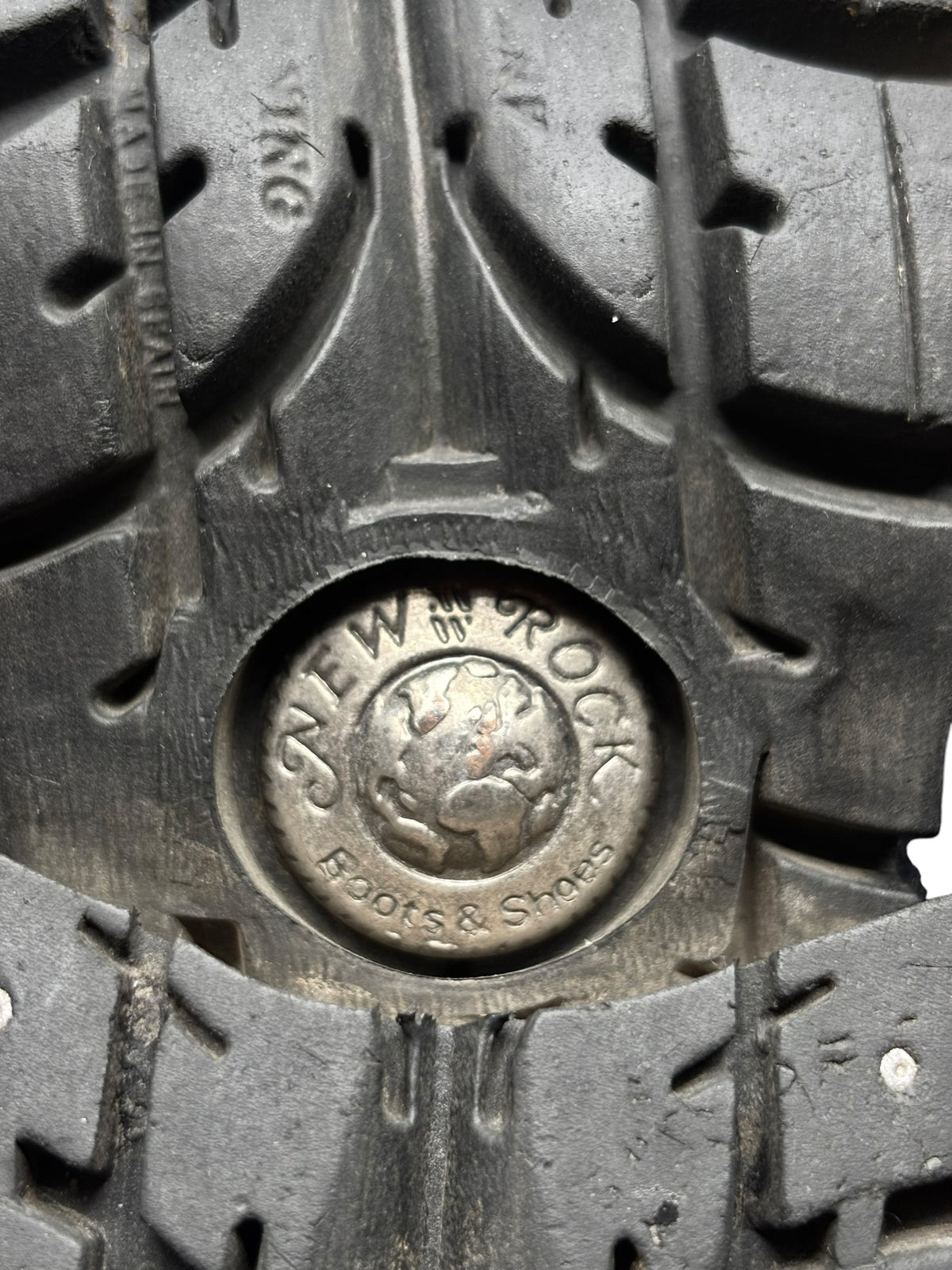Boot outsole close-up with raised tread and circular brand emblem