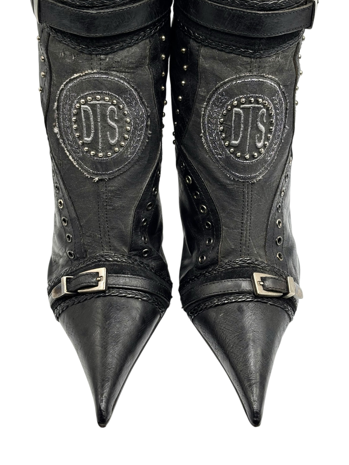 Knee-high vintage boots with pointed toe, buckle straps, and oval DS logo patches