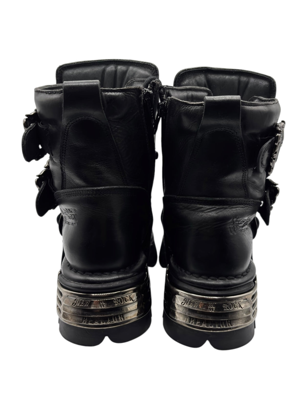 Back view of black platform boots with chunky heel and metallic nameplate at the sole