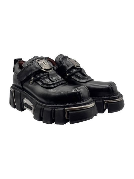 Vintage black platform boots with side buckle straps and chunky tread, angled