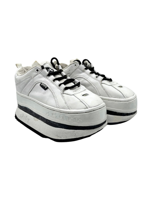 White lace-up platform sneakers with black-trimmed sole, side view of pair