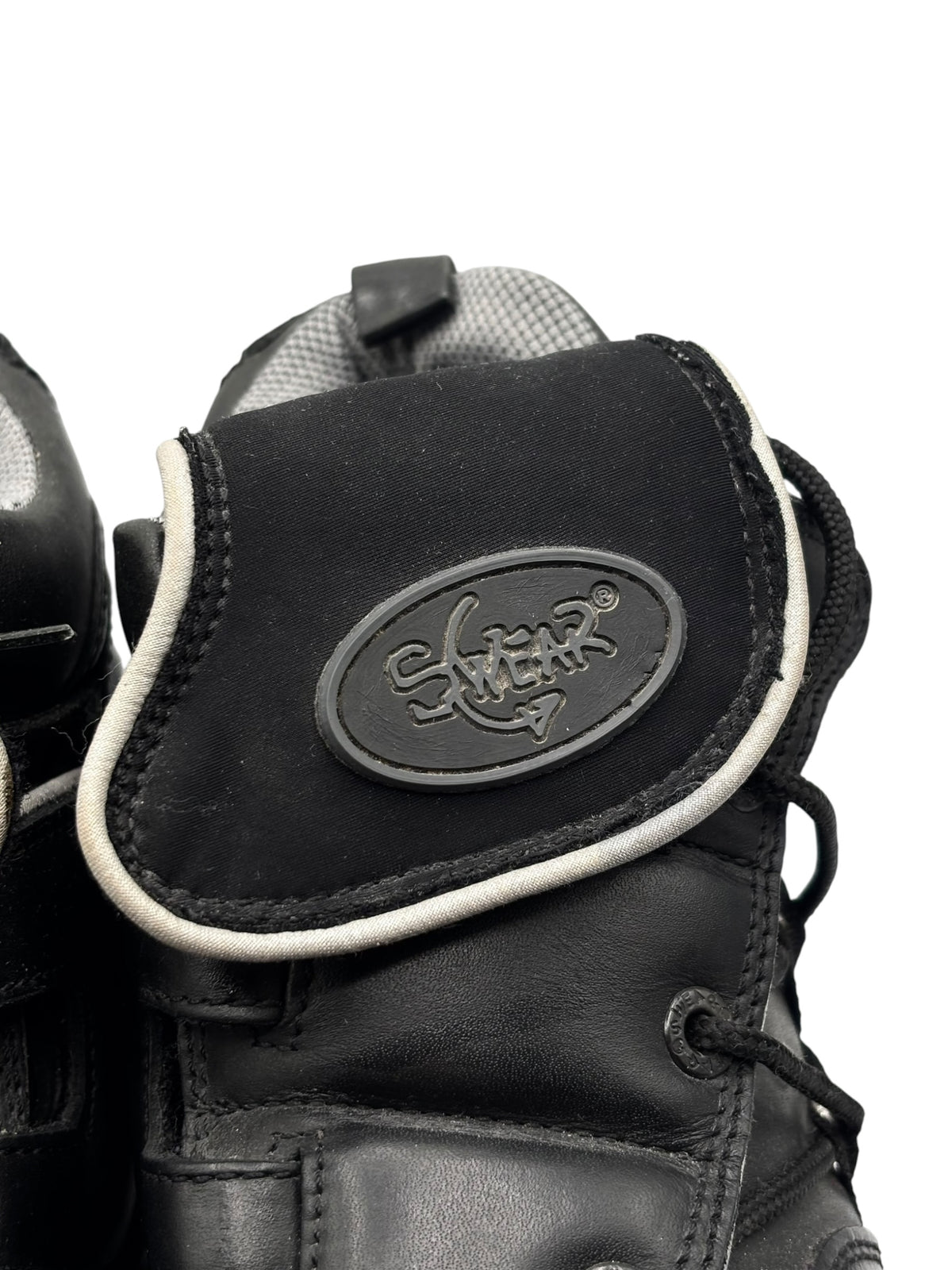 Black boot upper with oval “Swear” logo patch and light contrast trim.