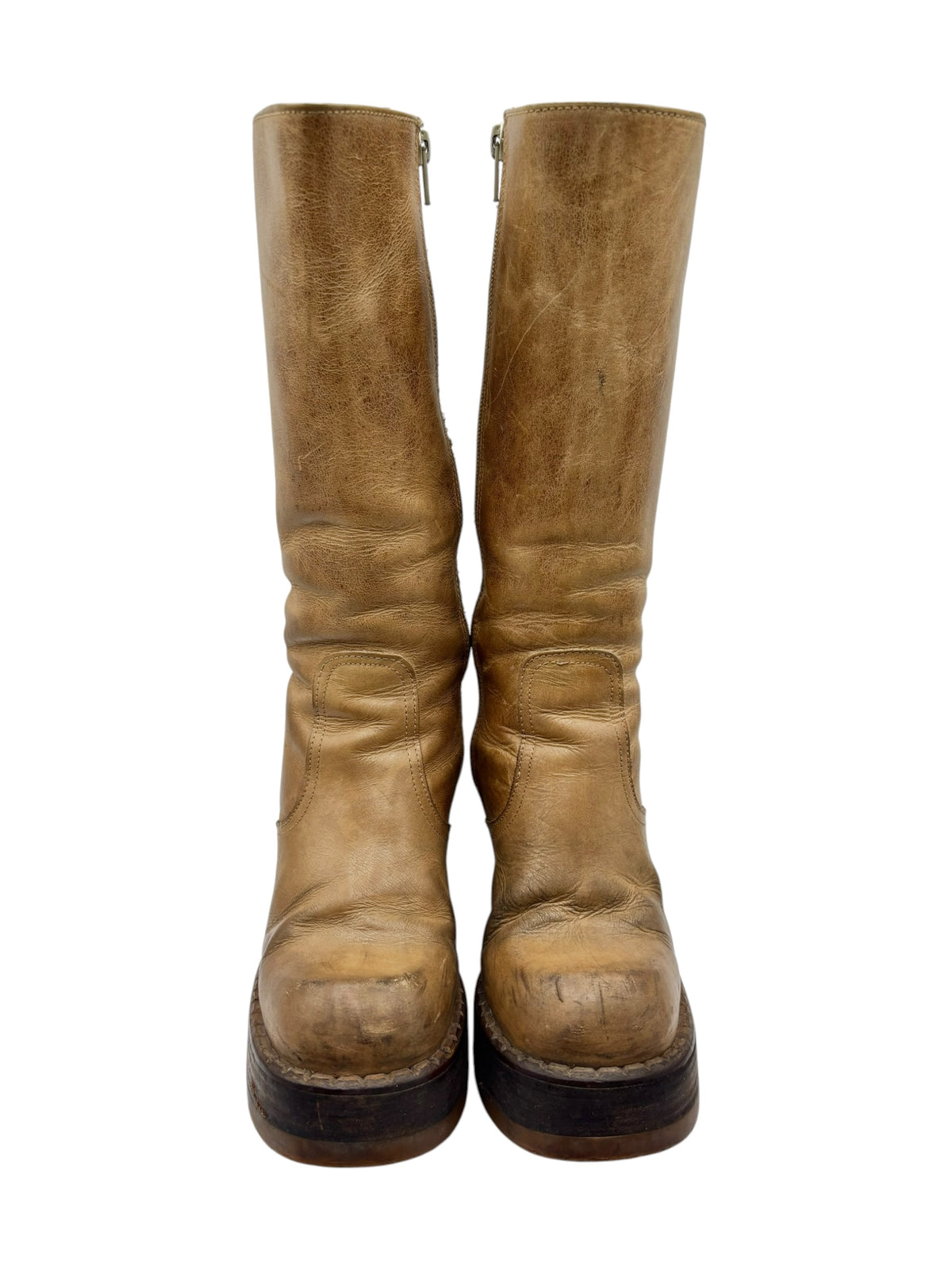 Front view of tan knee-high boots with side zippers and worn platform soles.