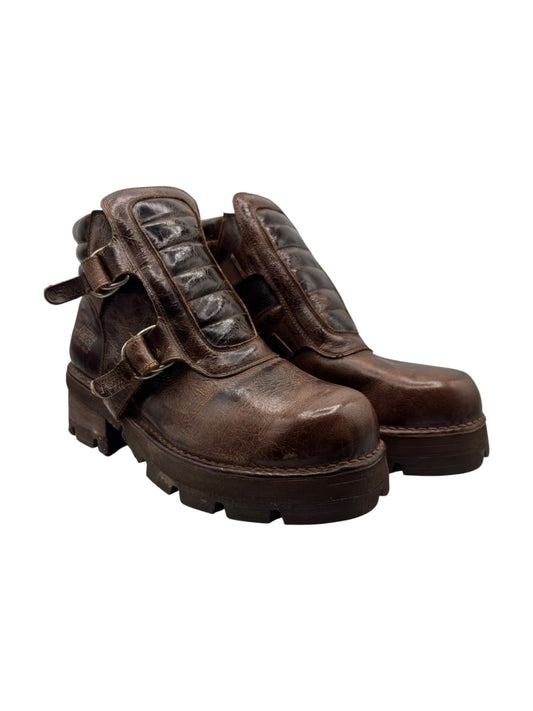 Brown distressed leather ankle boots with side straps and thick lug soles