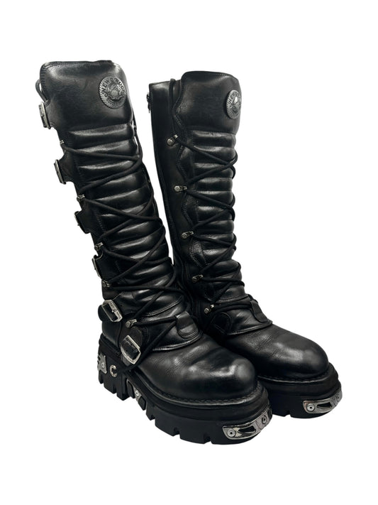 Knee-high black leather lace-up boots with buckles and chunky studded sole