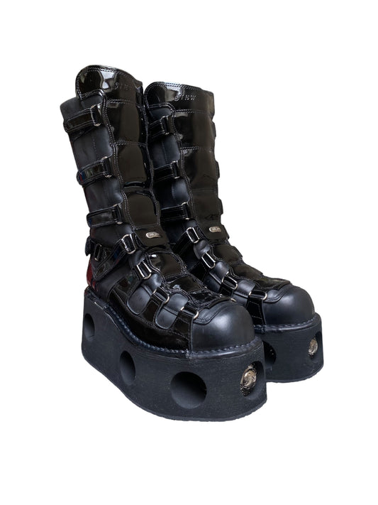 Black patent leather platform boots with buckle straps and chunky openwork sole