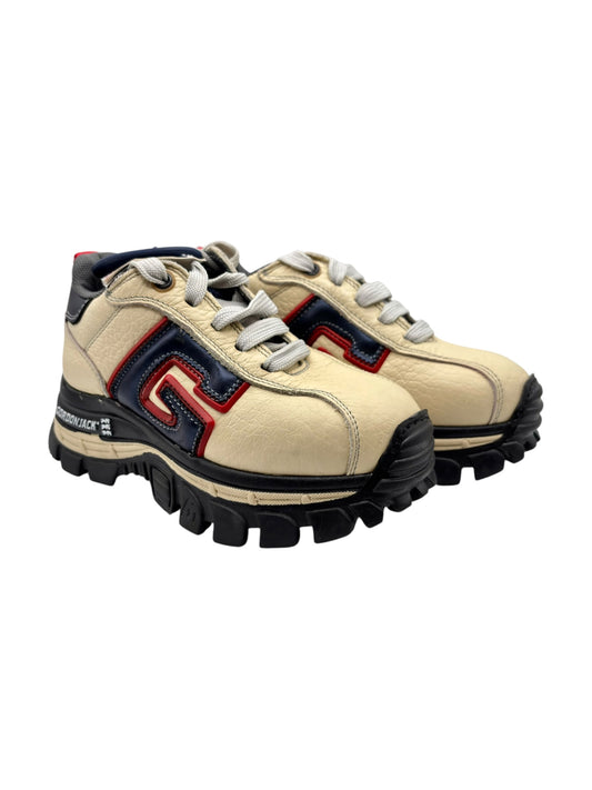 Beige platform sneakers with lace-up front, chunky tread sole, red and navy logo panel