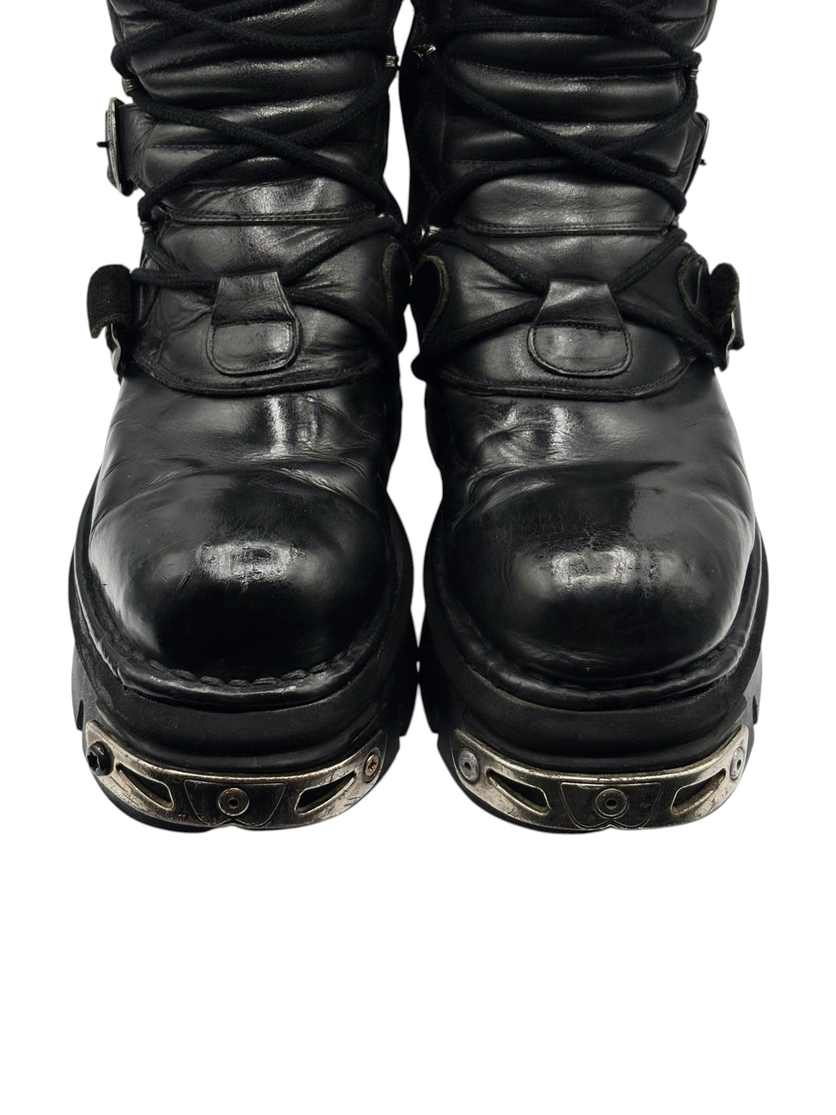 Black mid-calf reactor boots with rounded toes and patterned metal toe guard