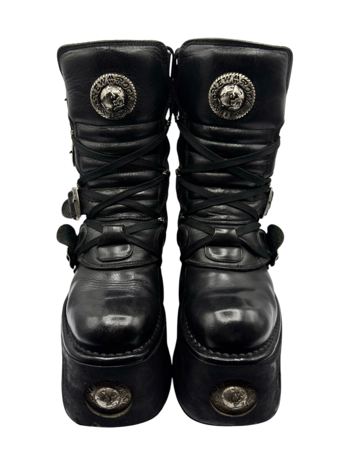 Black mid-calf platform boots front view with lace-up ties and embossed metal medallions