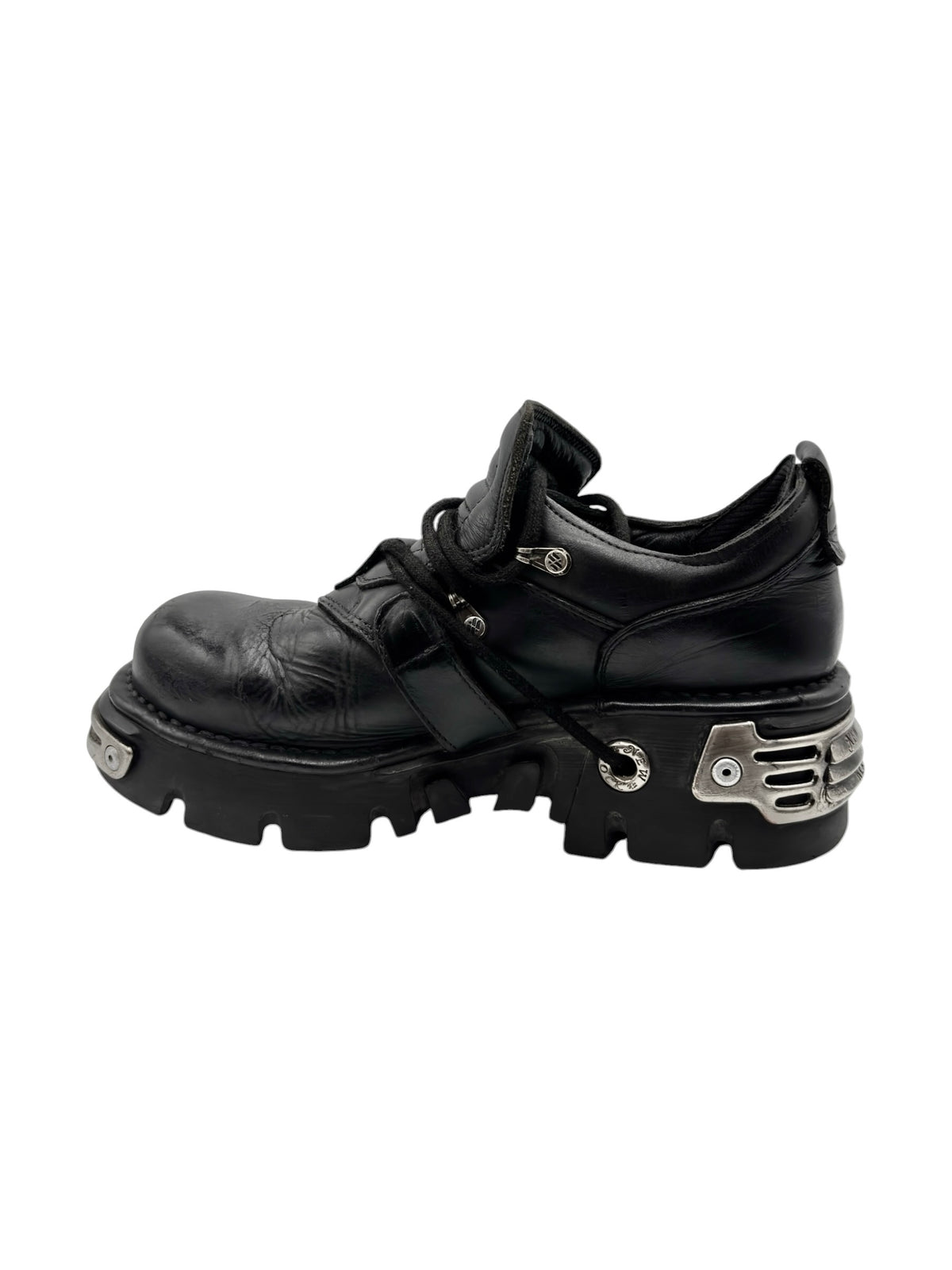 Black ankle platform boots with eyelet strap and buckle hardware over thick sole.