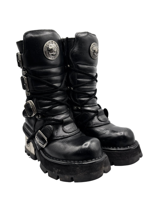 Black leather lace-up raised-heel boots with side buckles and round emblem patches