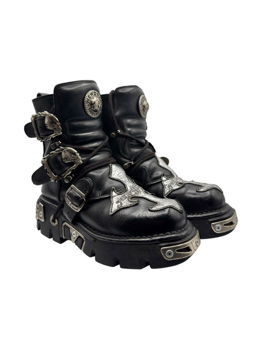 Black chunky lace-up boots with side buckles, silver cross patches, rugged sole