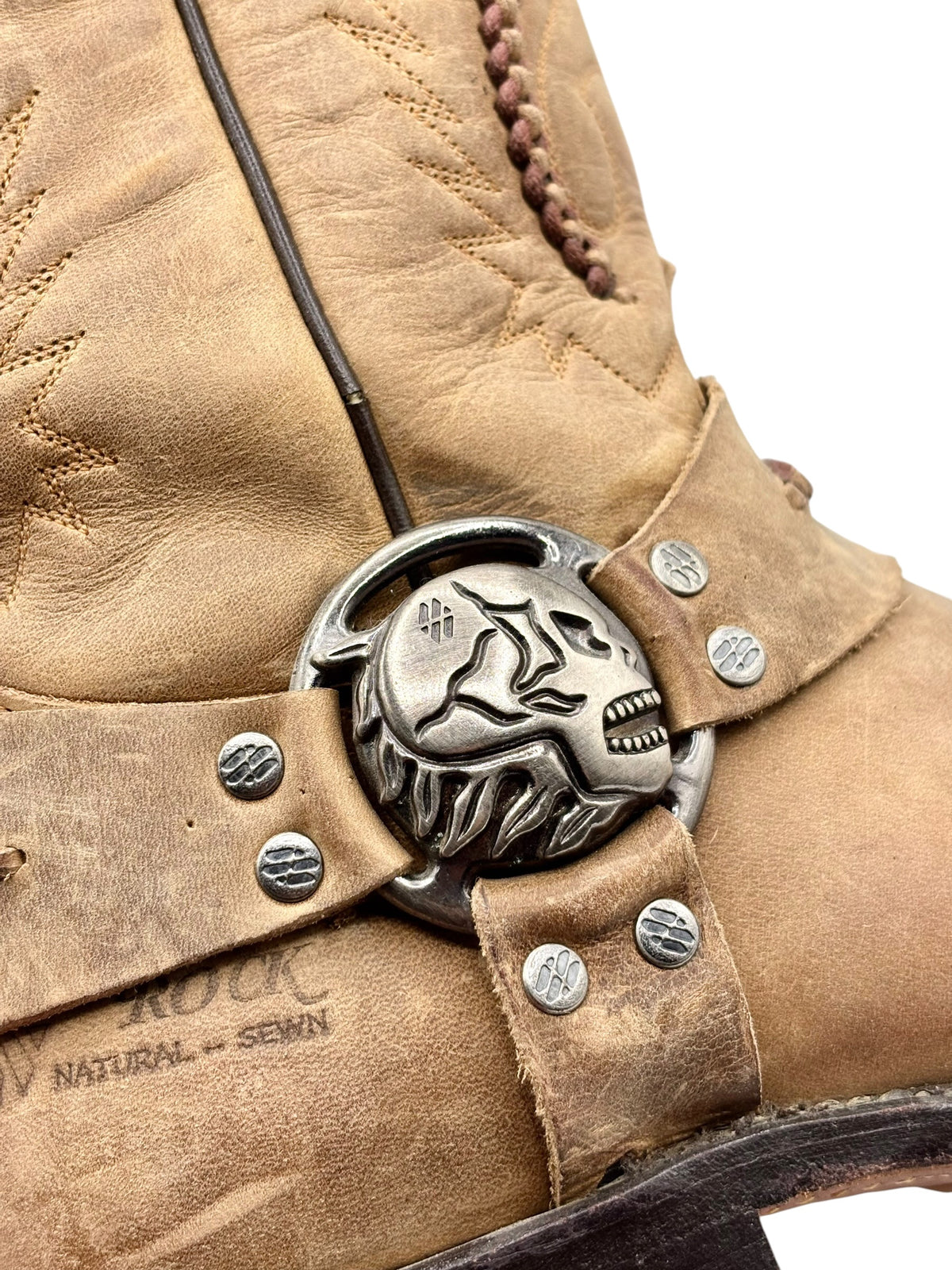 Beige boot cuff with large skull buckle and round stud details