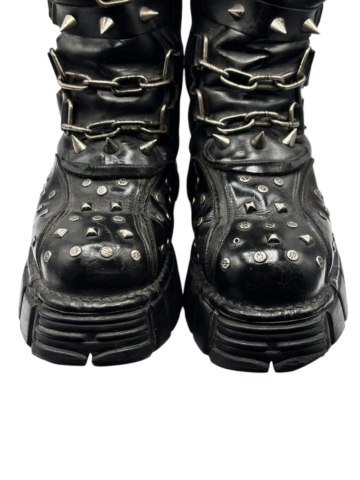 Studded chain platform boots in black, close-up of toe area with metal spikes and chain hardware
