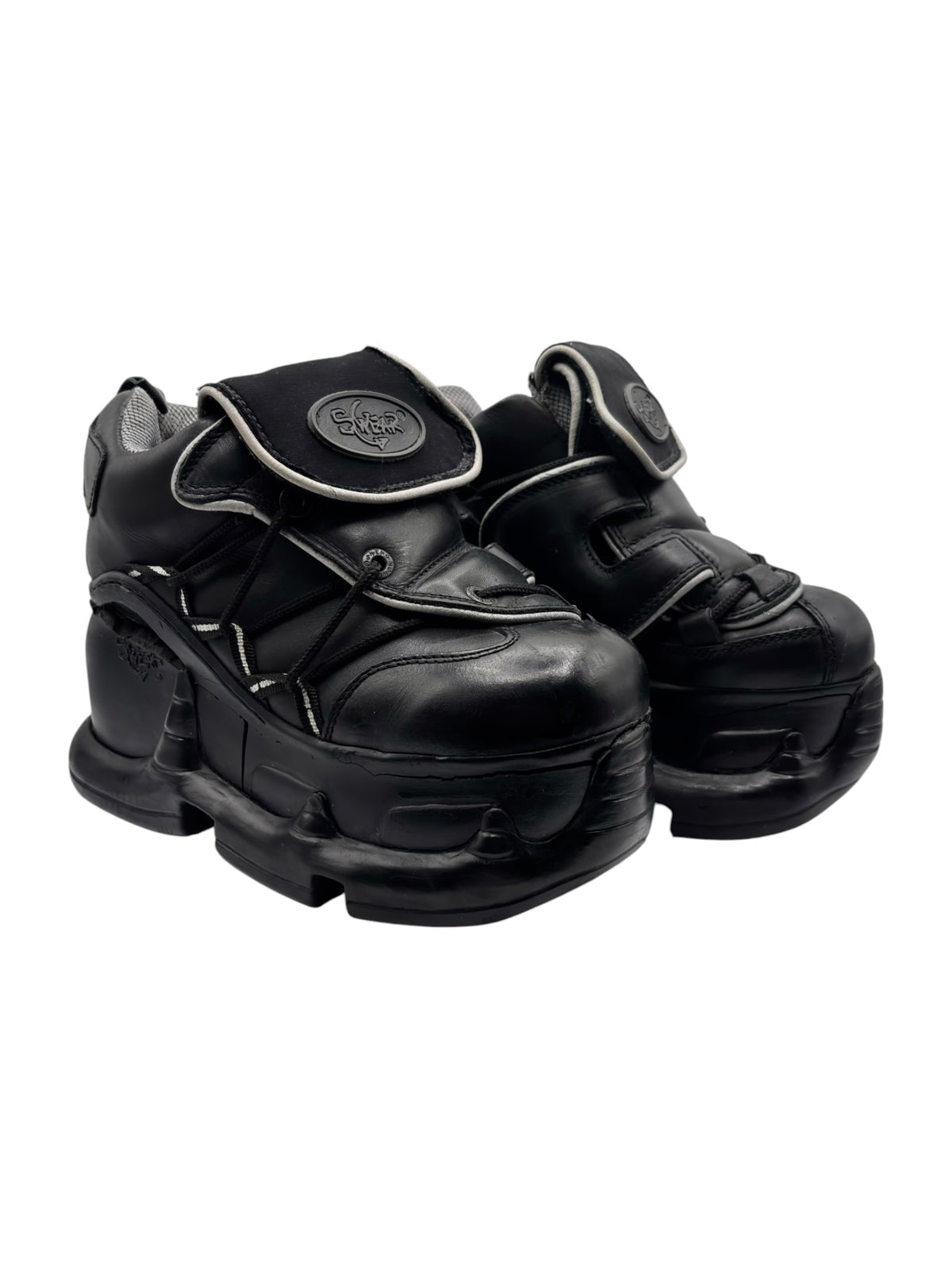 Black platform boots with front strap and chunky sole, three-quarter angle.