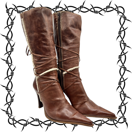 Brown distressed leather pointy-toe boots with zip front and crisscross lace ties.