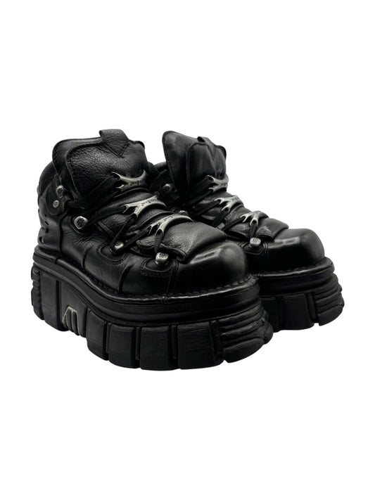 Black lace-up platform boots with sculpted upper and chunky tread sole.