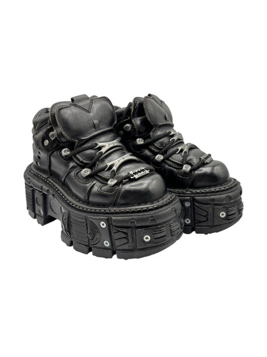 Black platform boots with lace-up front, chunky studded panels, and thick molded sole