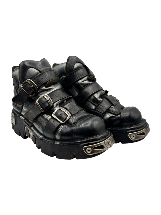 Side-by-side view of dark leather platform boots with two buckled straps and lug soles