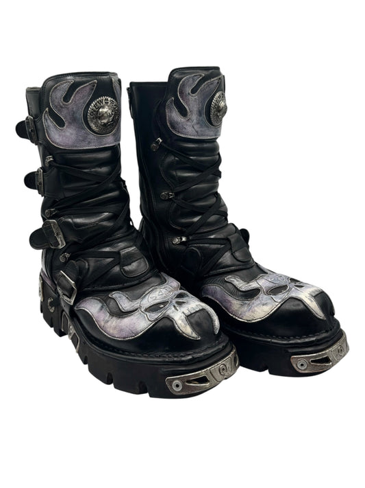 Angled pair of black boots with silver toe panels, side buckles, and chunky tread soles