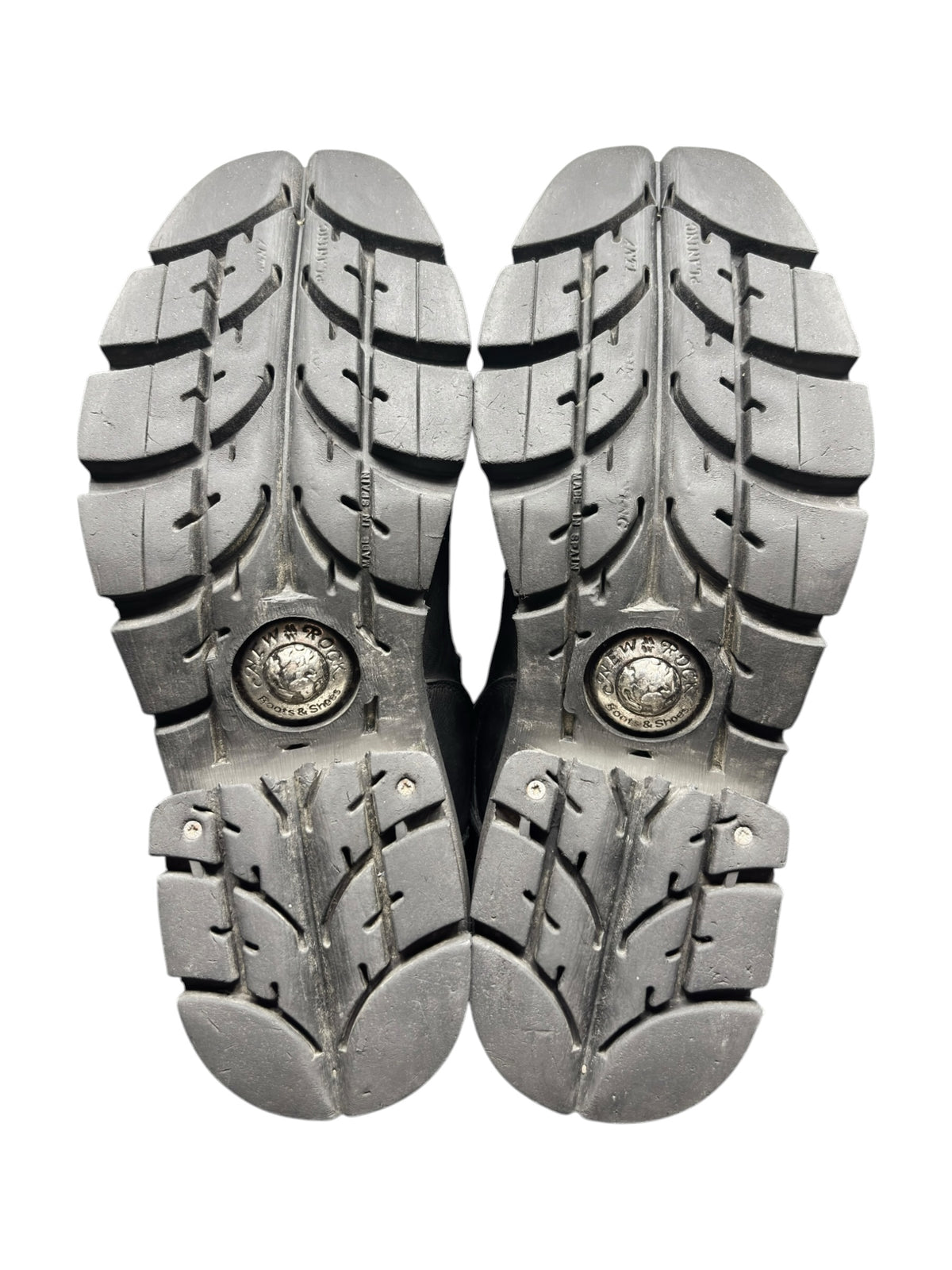 Pair of black mid-calf biker boot outsoles with deep tread pattern and emblem