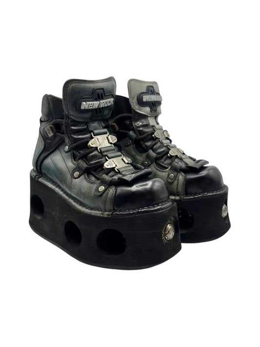 Dark green leather platform boots with metal buckles and perforated platform, side view