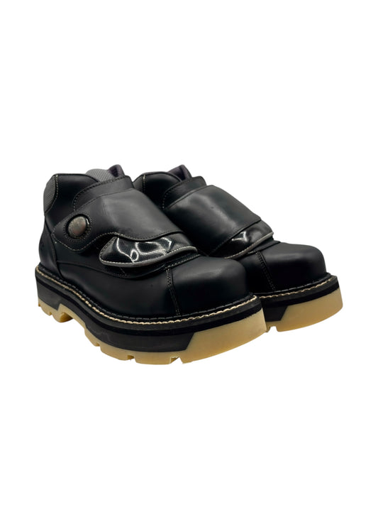Black platform boots with molded straps, perforated panel, and yellow-edged sole