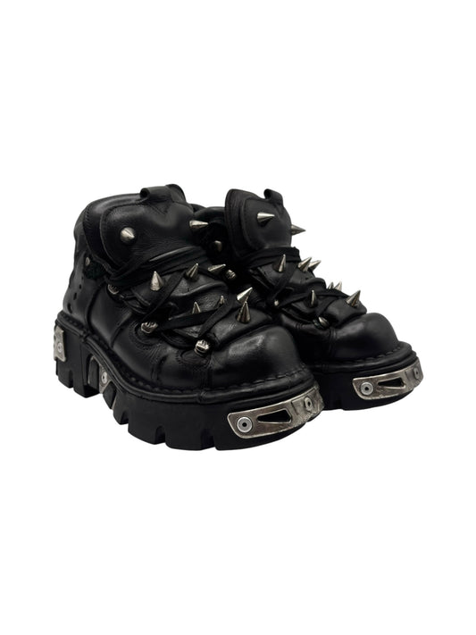 Black vintage platform boots with lace-up spikes and metal strap details