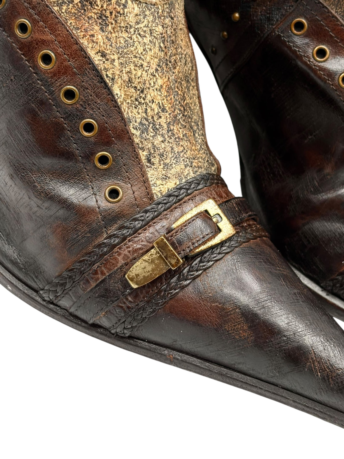 Knee-high boots close-up, dark brown leather with gold-tone buckle strap and textured sole