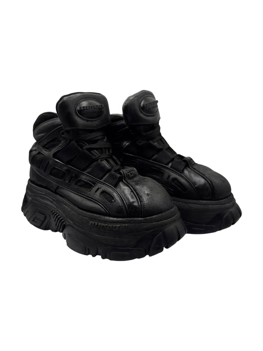 Black lace-up platform boots in profile, sculpted tread sole