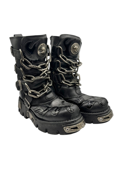 Black lace-up boots with chain straps, round side emblems, and chunky lug soles
