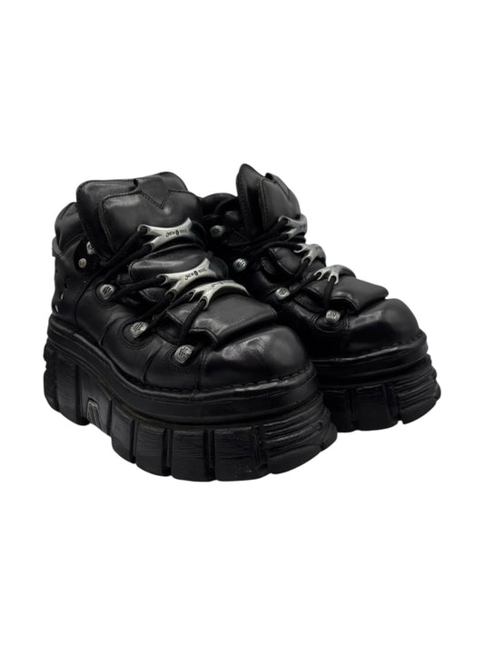 Black platform lace-up boots shown at an angle with thick tread sole