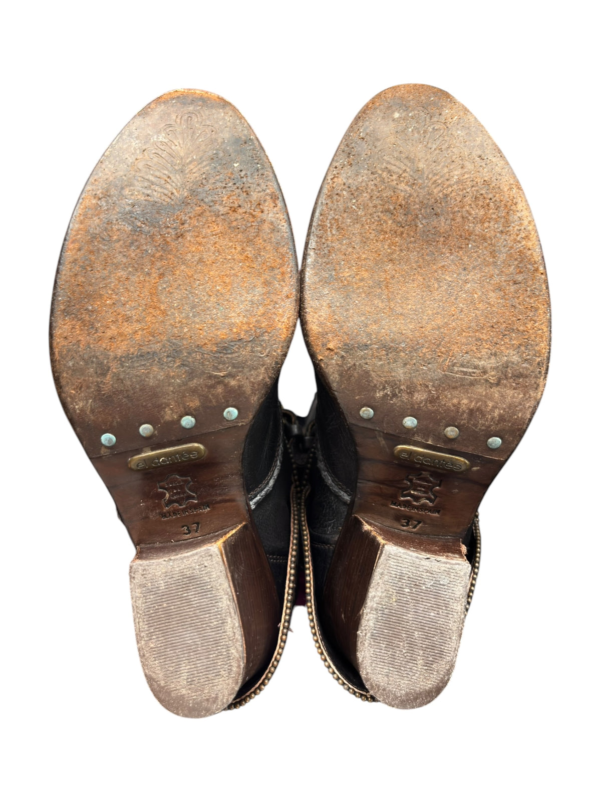 Pair of vintage knee-high leather boots with studbed soles and scuffed brown outsole