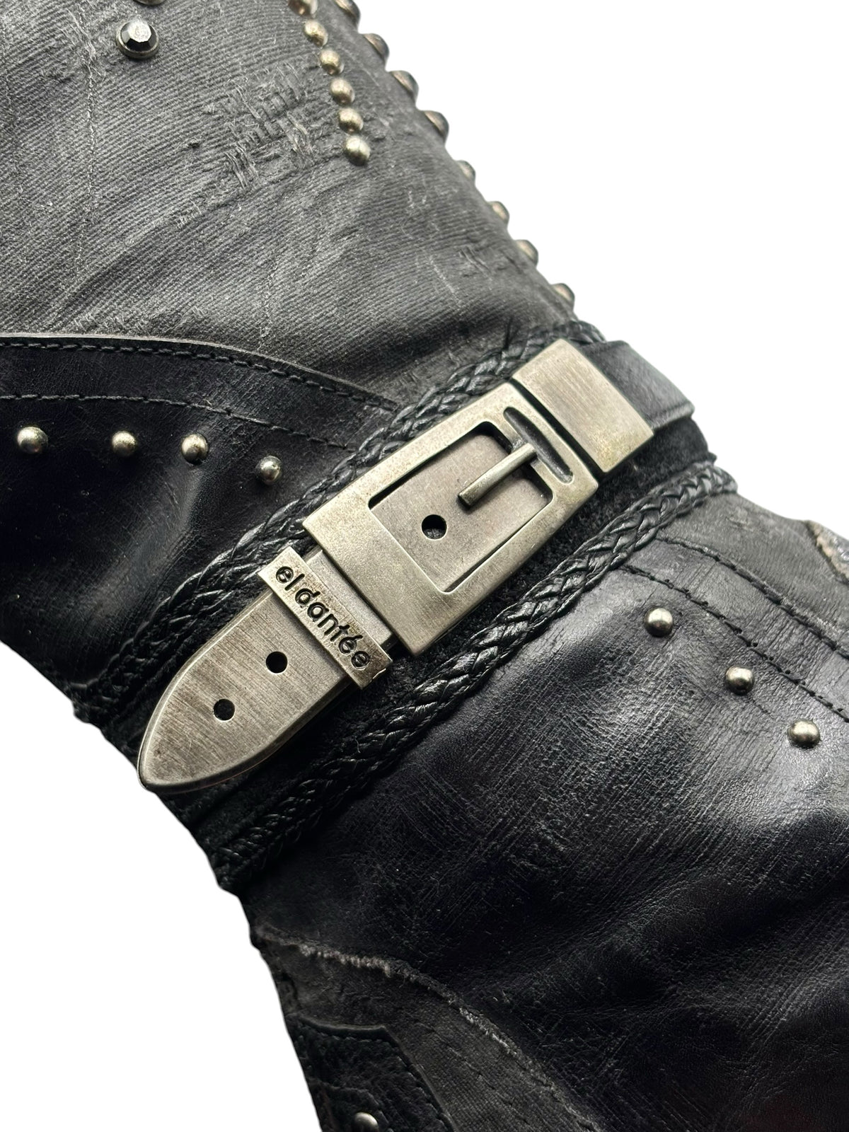 Knee-high boot strap buckle with metal logo plate and studded leather trim